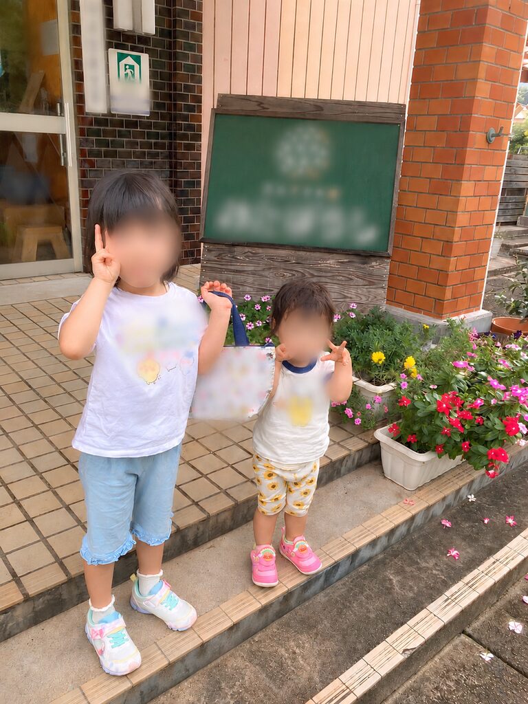 保育園の前で姉妹で写真撮影