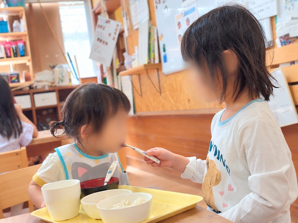 お姉ちゃんが妹にご飯を食べさせている